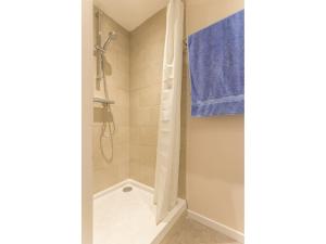 a bathroom with a shower with a blue towel at Maison lumineuse proche Nantes, jardin privatif, parking, Wi-Fi, cuisine équipée, équipements bébé - FR-1-306-1018 in Vertou