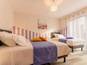 a bedroom with two beds and a chandelier at Grande maison en bois avec parc, terrasse, jeux et équipements modernes entre Nantes et Pornic - FR-1-306-1051 in Port-Saint-Père