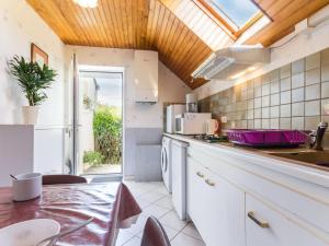 a kitchen with a dining table and a window at Location saisonnière: Gîte cosy avec jardin clos, proche plages et parc de Brière, wifi inclus! - FR-1-306-892 in Saint-André-des-Eaux