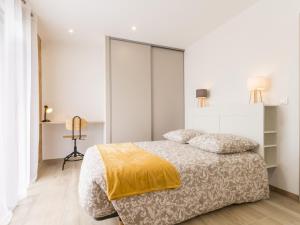 a white bedroom with a bed with a yellow blanket at Gîte moderne avec confort, près de la mer, jardin clos, garage, WiFi, et équipements bébé - FR-1-306-1173 in Arthon-en-Retz