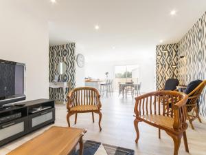 a living room with two chairs and a tv at Gîte moderne avec confort, près de la mer, jardin clos, garage, WiFi, et équipements bébé - FR-1-306-1173 in Arthon-en-Retz