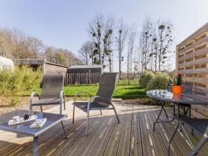 a patio with two chairs and a table on a deck at Gîte charmant cœur Parc de Brière, proche Guérande, jardin privatif, wifi, équipements bébé inclus - FR-1-306-983 in La Chapelle-des-Marais