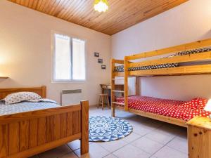a bedroom with two bunk beds and a desk at Gîte familial avec jardin clos, à 25 km de Nantes, WiFi, vélos et jeux pour enfants. - FR-1-306-953 in Rouans
