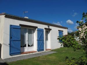 a white house with blue doors and a yard at Gîte familial avec jardin clos, à 25 km de Nantes, WiFi, vélos et jeux pour enfants. - FR-1-306-953 in Rouans