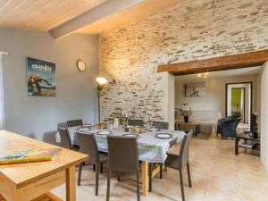a dining room with a table and chairs and a living room at Ancien Bâtiment de Ferme Rénové entre Nantes et Pornic avec Jardin et Activités - FR-1-306-1028 in Port-Saint-Père +8 photos
