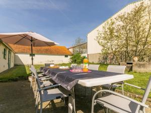tavolo e sedie con ombrellone e tavolo e sedie sidro di sidro di Gîte spacieux avec jardin, SPA, et équipements bébé près de Pornic - FR-1-306-1041 a Saint-Père-en-Retz