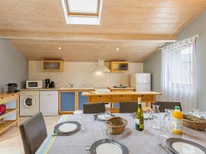 a dining room with a table and a kitchen at Ancien Bâtiment de Ferme Rénové entre Nantes et Pornic avec Jardin et Activités - FR-1-306-1028 in Port-Saint-Père