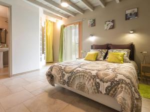 a bedroom with a large bed with yellow pillows at Gîte rénové avec jardin clos, proche Nantes, idéal famille, accessible PMR, wifi inclus - FR-1-306-1134 in Vay