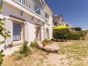ein Haus mit einer Bank und einem Sonnenschirm im Hof in der Unterkunft Appartements à Piriac-sur-Mer, plage, wifi, animaux acceptés - FR-1-306-1155 in Piriac-sur-Mer + 6 Fotos