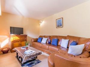 a living room with a brown leather couch and a table at Gîte spacieux avec jardin clos et accès mer à 100m, proche commerces - Saint-Brévin-les-Pins - FR-1-306-1049 in Saint-Brevin-les-Pins