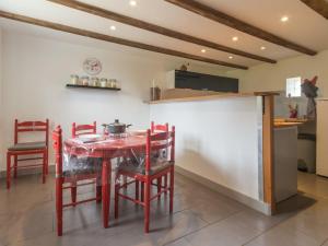 a kitchen with a red table and red chairs at Gîte Confortable avec Jardin, Proche Mer et Ville, Équipé pour Familles, Vélo Inclus - FR-1-306-1076 in Saint-Nazaire