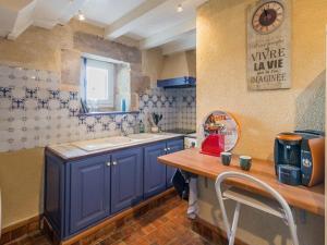 eine Küche mit blauen Schränken und einem Holztisch in der Unterkunft Charmant apt 17e s. à Guérande, 2 chambres, vue mer, wifi - FR-1-306-1084 in Guérande