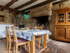 a dining room with a table with chairs and a stone wall at Charmante chaumière rénovée près des marais salants avec jardin clos et équipements modernes - FR-1-306-1072 in Guérande