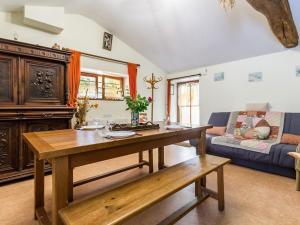 ein Wohnzimmer mit einem Holztisch und einer Couch in der Unterkunft Gîte Rénové avec Étang, Proche Nantes, Wi-Fi, Équipements Bébé - FR-1-306-1118 in Saint-Étienne-de-Corcoué