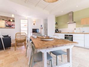 a kitchen and dining room with a wooden table and chairs at Gîte cosy bord de mer avec spa à 5 min de la plage et commerces, 2 terrasses, idéal famille et bébé - FR-1-306-1192 in Pornic
