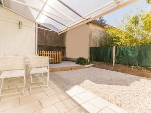 a patio with a white pergola and a table and chairs at Maison familiale moderne, 300m du centre, 500m de la mer, WIFI gratuit, draps inclus. - FR-1-306-1206 in Saint-Brevin-les-Pins +2 photos