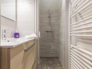 ein weißes Badezimmer mit Dusche und Waschbecken in der Unterkunft Maison bretonne rénovée près de la mer avec jardin, terrasse et équipements modernes - FR-1-306-1197 in Guérande