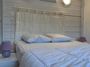 a white bed with two pillows on top of it at Charmant Gîte en Montagne avec Terrasse et Garage, Proche La Bresse Ski et Sentiers Balises - FR-1-589-17 in Cornimont