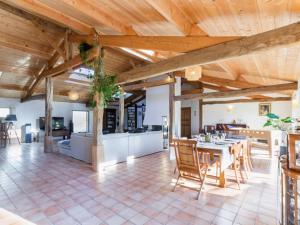 a dining room and kitchen with a table and chairs at Gîte familial spacieux avec piscine naturelle, proche Nantes - FR-1-306-1218 in La Limouzinière