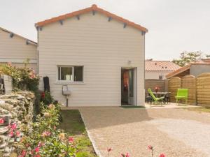 a white house with a patio and a table at Maison mitoyenne cosy à 200m de la mer avec terrasse, wifi et équipements bébé - FR-1-306-1062 in La Plaine-sur-Mer