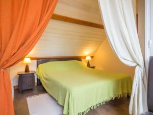 a bedroom with a green bed and two lamps at Gîte familial au cœur de la Vallée du Don avec jardin clos, activités et équipements complets - FR-1-306-1107 in Guéméné-Penfao