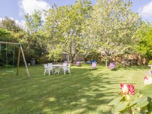a field with a table and chairs in a yard at Gîte familial dans le Parc de Brière - Jardin arboré, terrasse, activités ludiques, Wifi inclus - FR-1-306-1101 in Herbignac +3 photos