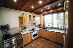 a kitchen with wooden cabinets and a large window at Holiday house with a parking space Ribarici, Gorski kotar - 24269 in Ogulin