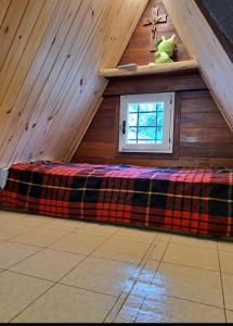 a room with a bed in a attic with a window at Anto'n casa de montaña in Potrerillos