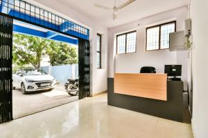 an office with a reception desk and a car parked in a garage at Hotel O Capital Pearl in Patna