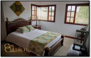a bedroom with a bed in a room with windows at Casa Caballero Hotel Boutique in Salento