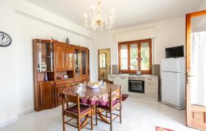 a kitchen with a table with chairs and a chandelier at 4 Bedroom Awesome Home In Modica in Modica