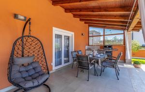 a porch with a swing and a table and chairs at 2 Bedroom Stunning Home In Skatari in Šikići