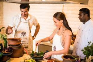 a man and a woman preparing food in a kitchen at Anantara Peace Haven Tangalle Resort in Tangalle