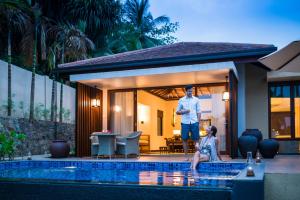 a man standing next to a swimming pool in a house at Anantara Peace Haven Tangalle Resort in Tangalle