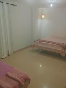 une chambre avec deux lits avec des draps roses dans l'établissement Casa Sobrado Confortavel, Descanso Garantido, à Cuiabá