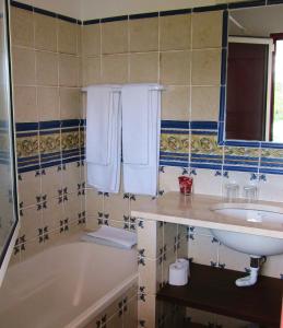 a bathroom with a tub and a sink and a bath tubermottermott at Monte Novo da Longueira Turismo Rural in Longueira