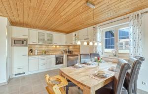 eine Küche und ein Esszimmer mit einem Holztisch und Stühlen in der Unterkunft Ferienhaus 4 Altefähr in Altefähr