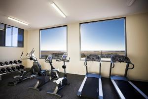 a gym with tread machines and large windows at Mantra Tullamarine Hotel in Melbourne