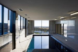 a swimming pool in the middle of a building with windows at Mantra Melbourne Airport in Melbourne