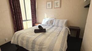 a bed with a black purse on top of it at Riverview Kalbarri 5 | Waterfront | Pool | Sleeps 5 in Kalbarri