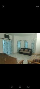 a living room with two beds and blue curtains at Casa Blu in Île Pilau