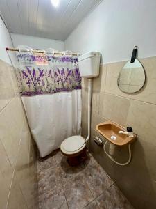a small bathroom with a toilet and a sink at Pousada Rosa de Saron - Algodoal in Algodoal