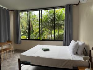 ein Schlafzimmer mit einem Bett und einem großen Fenster in der Unterkunft Phines Place in Panglao
