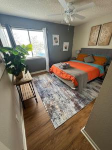 博尔德2BR Gem in the heart of Boulder - Pets Allowed, Gym & Pool的一间卧室配有一张带橙色床单的床和风扇