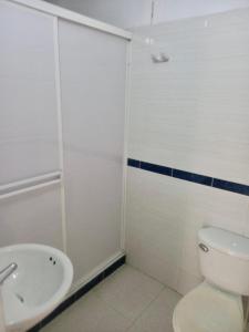 um banheiro branco com um vaso sanitário e uma pia em Hotel mantarraya em Rodadero mais 13 fotografias