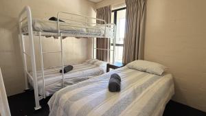 Un dormitorio con dos literas y una ventana. en Riverview Kalbarri 27 | Family Apt | Pool | Sleeps 7, en Kalbarri