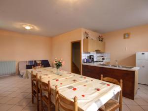 una cucina con un lungo tavolo in una stanza di Gîte familial avec jardin clos, idéal pour randonnées et escapades nature, animaux acceptés - FR-1-496-196 a La Chambonie