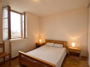 una camera da letto con un letto e due lampade su due tavoli di Gîte familial avec jardin clos, idéal pour randonnées et escapades nature, animaux acceptés - FR-1-496-196 a La Chambonie