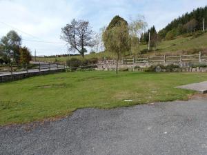 un prato erboso con una recinzione e un albero di Gîte familial avec jardin clos, idéal pour randonnées et escapades nature, animaux acceptés - FR-1-496-196 a La Chambonie Altre 2 foto