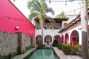 an exterior view of a house with a pool in the courtyard at Los Suspiros Hotel Boutique & Spa in Comala